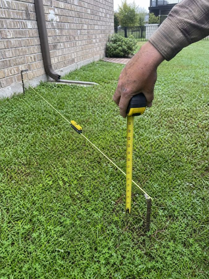 Measuring the slope of a yard with mason line and a tape